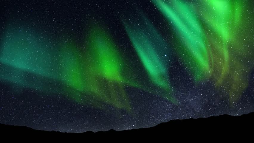 Aurora Borealis interweaving with the Milky Way Galaxy. Northern Lights Time Lapse Solar Wind. Dance of Celestial Lights. Northern Lights twirling with solar wind flaring in green and purple