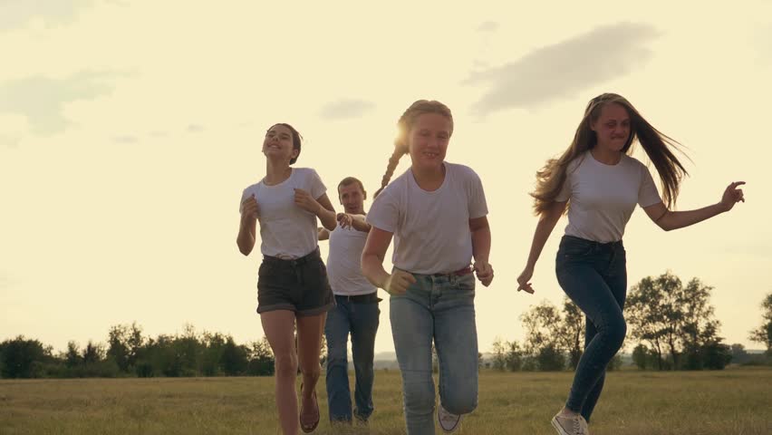 A happy family runs in the park at sunset. A team of people running together. Family dad mom and happy kids have fun weekends. Happy children Royalty-Free Stock Footage #3456693945