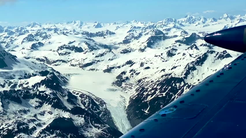 Glacier seen from small airplane in Lake Clark Pass, Alaska. Dark debris lines called lateral or medial moraines along the edges and down the center of glacier. 