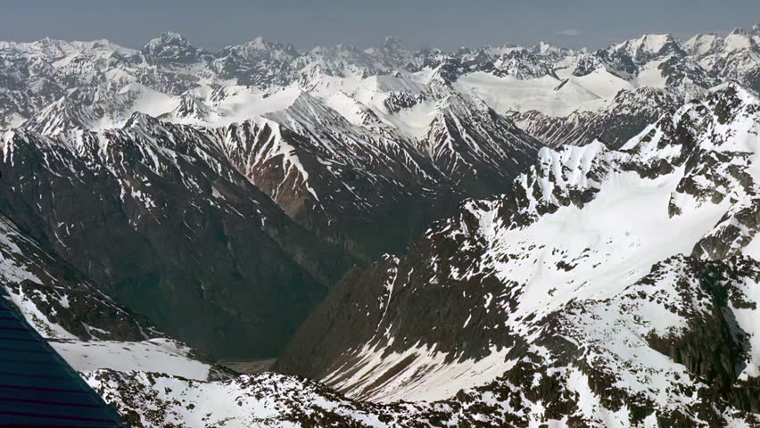 Beechcraft Bonanza airplane wingtip flies over Lake Clark Pass in Alaska. Mount Redoubt in the background. Small aircraft are only way to see many areas of Alaska.