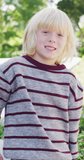 Vertical video portrait of happy caucasian boy with long blonde hair smiling in garden. Childhood, domestic life, health and happiness concept digitally generated video.