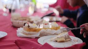 Cropped video of people cutting and eating sweet delicious cakes at table	