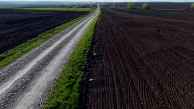 Dynamic aerial video from flying drone of rich black soil fields for cultivating organic products and long countryside road