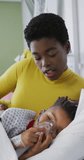 Vertical video of african american woman and her son at hospital. Medicine, healthcare, lifestyle and hospital concept.