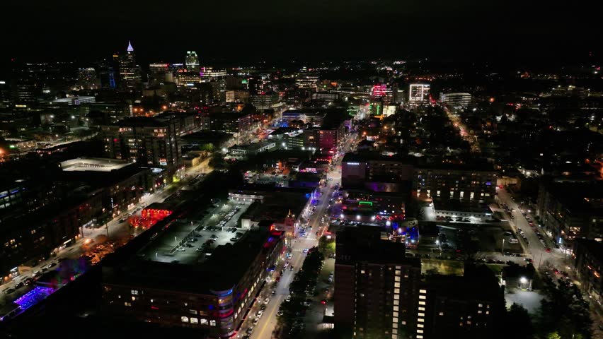 Slow Aerial View of Raleigh, NC. From Glenwood South to the Downtown Raleigh Skyline on a Saturday night. Great view of a vibrant nightlife in Glenwood South. Royalty-Free Stock Footage #3456853651