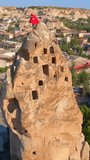 Vertical video. Aerial shot of Goreme, Cappadocia, Turkey. The ancient city unfolds below, revealing its extraordinary charm with houses gracefully carved into the rocks.