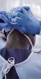 Vertical video of african american male doctor wearing face mask. Global medicine, health, lifestyle and hospital concept.