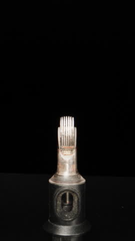 Needles for a tattoo machine, close-up. On a black background. Dolly slider extreme close-up. Vertical video.