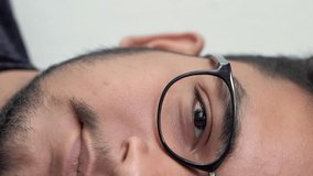 Vertical video. Man face. Studio portrait. Positive attitude. Half headshot of handsome calm young beardy guy in glasses smiling isolated on light background. - Powered by Shutterstock - Get 15% off with code: PIKWIZARD15