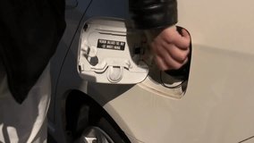 Refueling a car with fuel, Filling fuel into a car tank. driver refuels auto gas station for cars. The car's tank cap is open with diesel fuel economy
