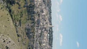 Vertical video. Matera, Italy. The old part of the city is carved into the rock and is a UNESCO World Heritage Site. Summer day, Aerial View, Point of interest