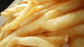 French fries are a beloved snack made from deep-fried potato strips. They are crispy on the outside and soft on the inside, often served hot and seasoned with salt. French fries background. 4K HDR.
