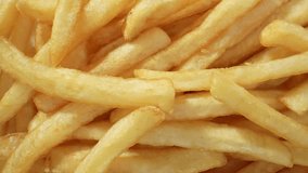 Crispy golden French fries, a beloved classic, are thinly cut potatoes deep-fried to perfection, offering a satisfying crunch and fluffy interior. Junk food concept. Fast-food background. 4K UHD.
