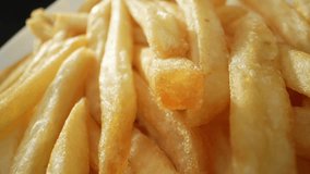Golden strips of potatoes, fried to crispy perfection, French fries tantalize taste buds with their salty crunchiness, a beloved classic worldwide. Carbohydrate concept. French fries background. 4K.
