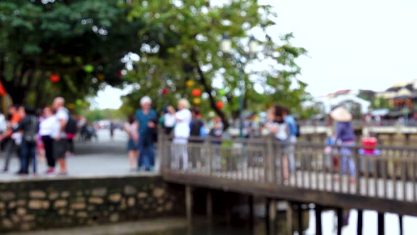 Blurred crowd of different people are walking in Hoi An city 