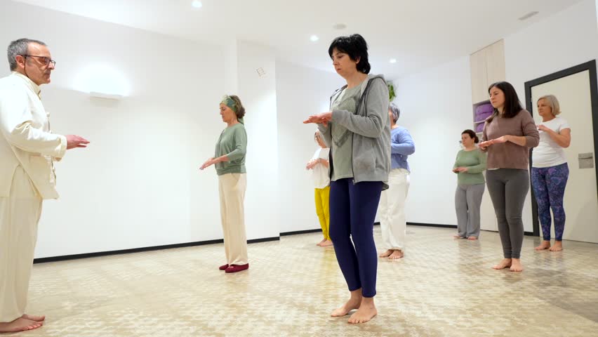 Group of mature caucasian women stretching during qigong class leaded by instructor Royalty-Free Stock Footage #3457043039