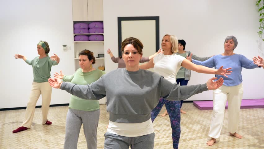 Group of mature adult and caucasian sportive women opening arms during qi gong class Royalty-Free Stock Footage #3457043529