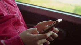 Close up. Girl using smartphone internet surfing communication online in bus. Scrolling pictures in application typing message. Child holding phone checking news. Playing games phone in train. Public - Powered by Shutterstock - Get 15% off with code: PIKWIZARD15