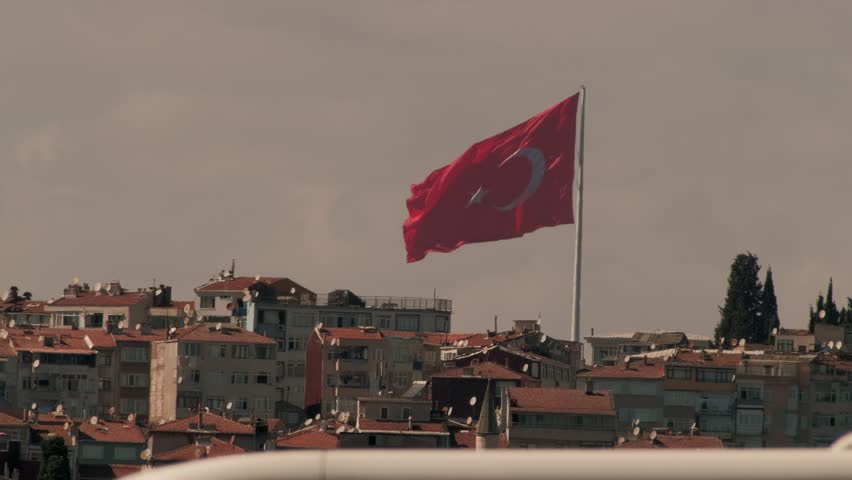 The Turkish flag flutters against the city landscape. Turkey, Istanbul.