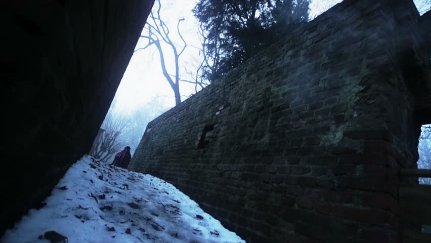 Walking on corridor of a bridge with snow on the ground, dressed as the peruvian of the Andes