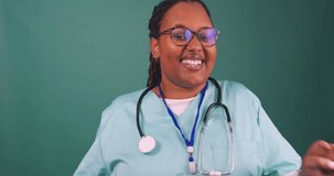 Young Black female doctor dances and laughs wearing scrubs and stethoscope