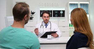 Mature Doctor Man Cheerful Conversation with Young Couple Take Note in Clipboard
