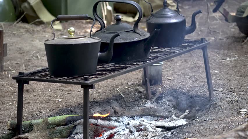 Pots and kettle over camp fire during camping trip