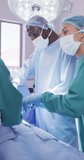 Vertical video of diverse surgeons with face masks during surgery. Global medicine, health, lifestyle and hospital concept.
