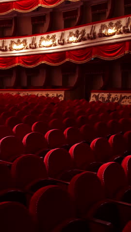 Empty classic theater. Rows of empty red velvet seats inside a theater or opera. No people in hall because of pandemic. Selective focus on opera interior. Vertical video.