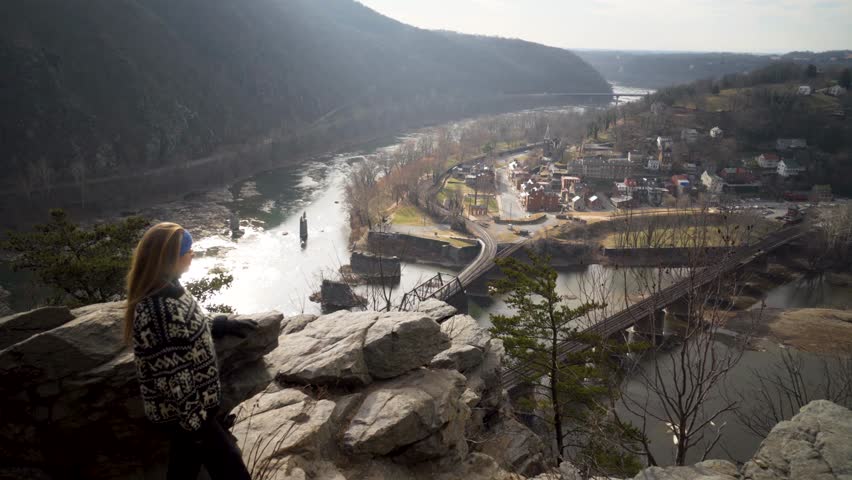 Steadicam gimbal motion of mature blonde woman enjoying view at an overlook at Maryland Heights of Harpers Ferry National Park.