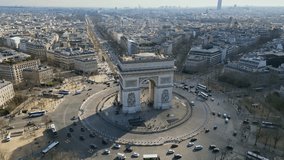 Arc de Triomphe and car traffic on roundabout, Paris cityscape, France. Aerial orbiting