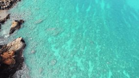 Amazing aerial drone video of a free diver swimming in tropical Hawaiian exotic destination with turquoise calm ocean surface. The southern coast of Maui in Hawai'i. Pacific coastline .