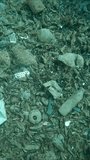 Top view, Large accumulation of plastic debris at the bottom of sea in a crevice between rocks, Spiral upward movement, Slow motion, Rhodes island, Greece