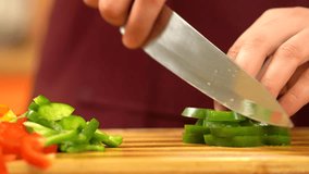 Man is cutting green paprika. Chef cutting green pepper using knife on wooden board. Man chopping pepper into cubes. Healthy, green food. Preparing Vegetable for salad.  - Powered by Shutterstock - Get 15% off with code: PIKWIZARD15