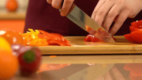 Cutting red bell pepper in dices with knife. Chef's hand chopped bell pepper on cutting, wooden board. Vegetable salad. Man cutting a slice of red paprika. Healthy Food. - Powered by Shutterstock - Get 15% off with code: PIKWIZARD15