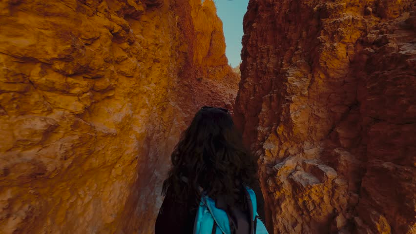 Young brunette woman hiking in Bryce Canyon National Park in Utah with hoodoos and red sandstone rock