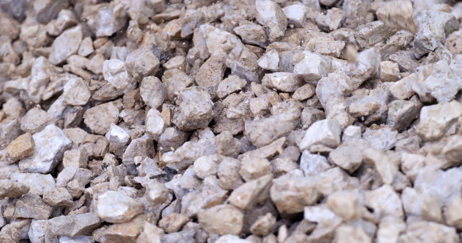 Super slow motion macro of falling light color gravel stones on ground during quality control and sorting process at concrete plant industrial factory at 1000 fps. Royalty-Free Stock Footage #3457381295