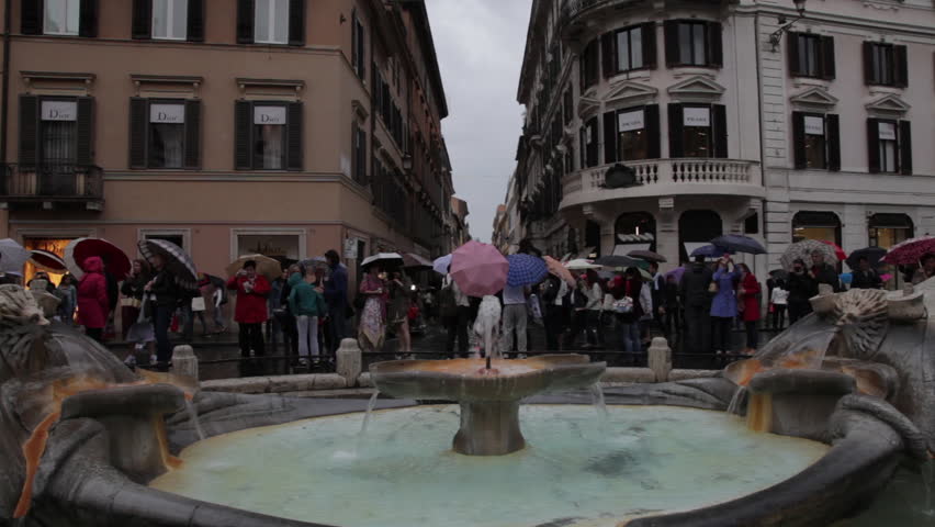 Shot of tourists looking down the Via dei Condotti from the Fontana della