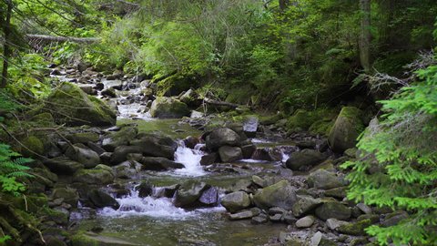 Clear water of a mountain river passes through a cascade of boulders. Carpathian mountains, Ukraine. Landscape video. Nature video. 4K, 3840*2160, high bit rate, UHD
