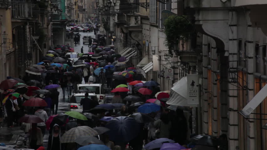 Cars traveling down umbrella filled Via dei Condotti