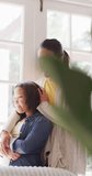 Vertical video of biracial mother comforting sad daughter at home. Family, motherhood, relations and spending quality time together concept digitally generated video.