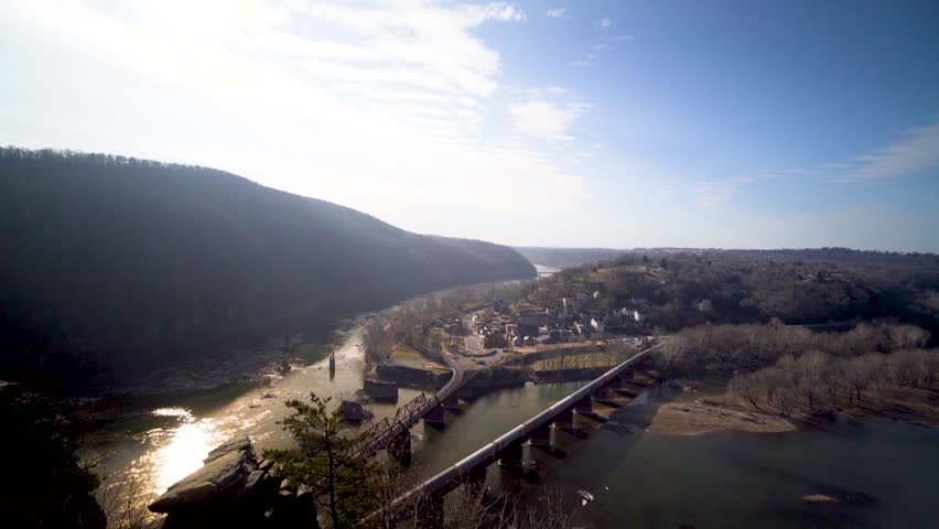 Camera pitches down from the sky to reveal Harpers Ferry National Park and the Potomac and Shenandoah Rivers as seen from Maryland Heights.