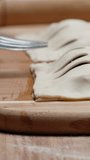 I seal the dough around the edges with a fork, pies with stuffing, close-up. Vertical video Social Media