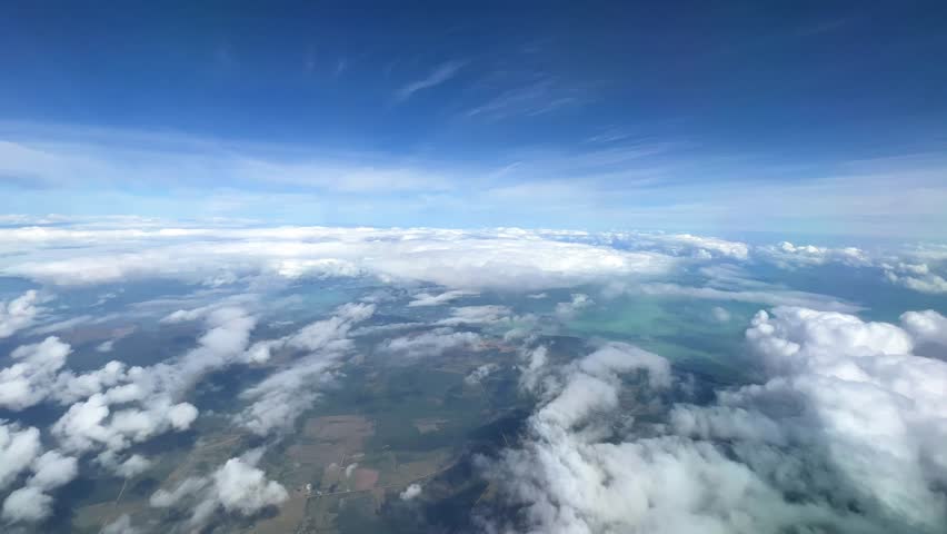 VARADERO, CUBA - DECEMBER 20, 2023: View from the porthole on the Atlantic coast of Cuba. View of the turquoise ocean water and islands with snow-white sand from the plane. White clouds over the water