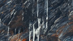 Meltwater slowly drips from the fragile glittering icicles hanging from the dark withered rocks. - Powered by Shutterstock - Get 15% off with code: PIKWIZARD15