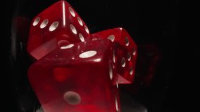 Red dices with white dots thrown into transparent glass illuminated by bright studio light. Gaming cubes with equal points on faces in wineglass on black background macro - Powered by Shutterstock - Get 15% off with code: PIKWIZARD15