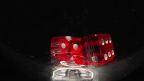 Red dices with white dots thrown into empty glass hitting on sides at bright light. Small cubes for gambling games rotate in wineglass on black background macro - Powered by Shutterstock - Get 15% off with code: PIKWIZARD15