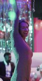Vertical video of happy caucasian woman dancing on dancefloor at a nightclub. Fun, music, going out and party concept.