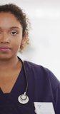Vertical video of portrait of happy african american female doctor. Global medicine, health, lifestyle and hospital concept.