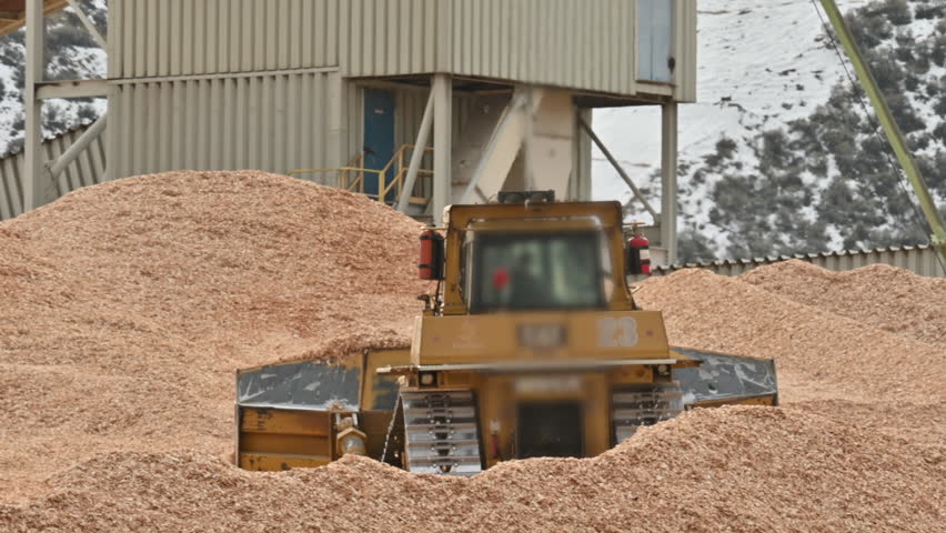 Bulldozer Clears Sawdust in Bustling Industrial Zone" Royalty-Free Stock Footage #3457662767